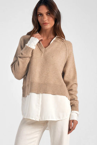 Taupe and white sweater blouse top being worn by a woman in front of a white background. Paired with simple and classic cream pants for a chic corporate look