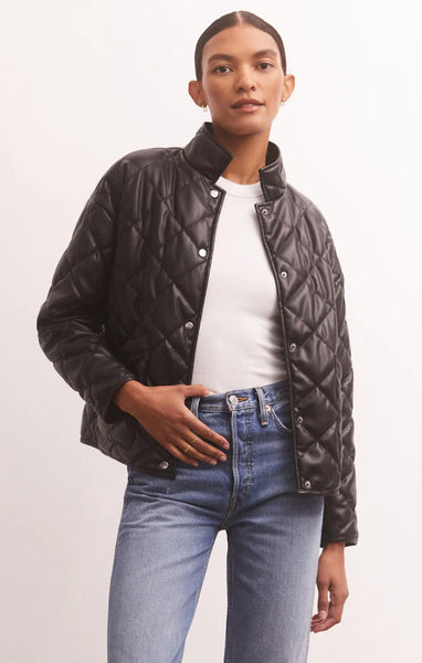 Woman wearing black faux leather quilted jacket with a white background. Pair it with your classic white t-shirt and favorite pair of denim